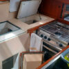 Boat galley with lockers propped open - prepare the galley before leaving the boat
