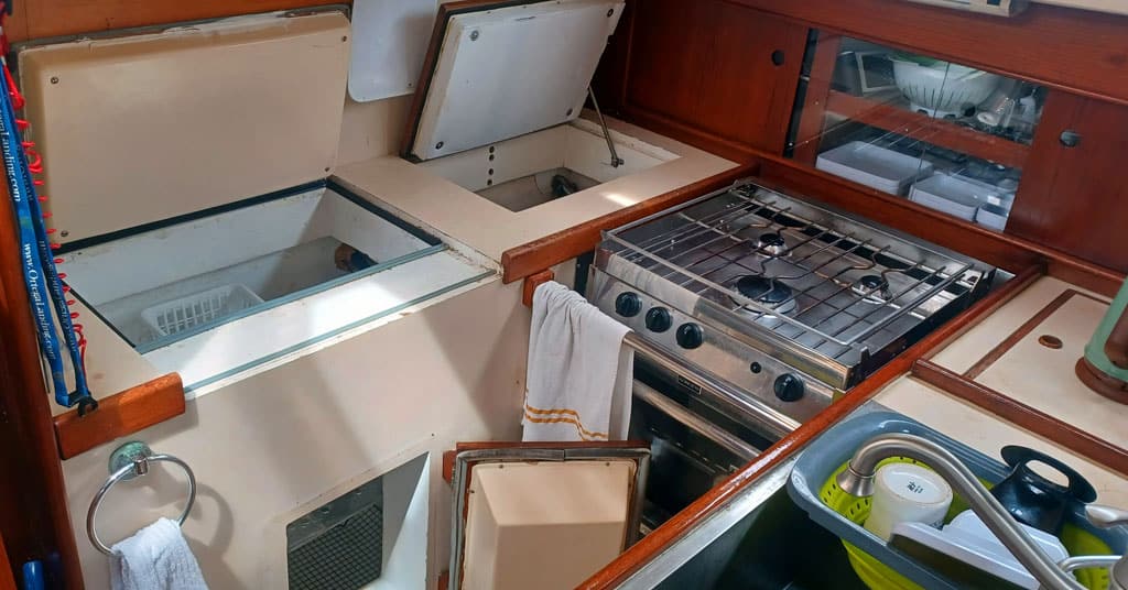 Boat galley with lockers propped open - prepare the galley before leaving the boat