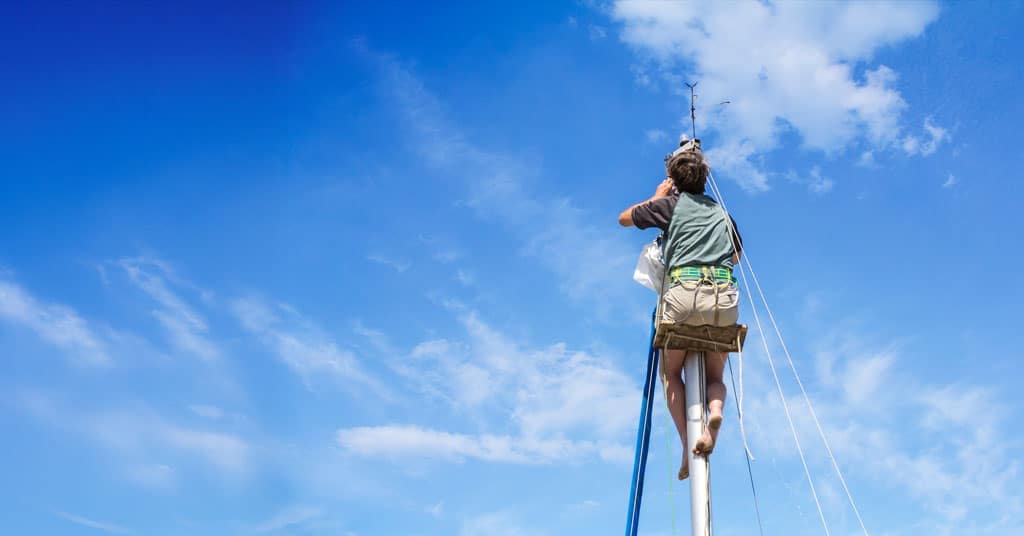 Person on a bosun's chair at the top of a mast - climbing the mast