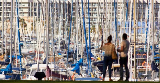 Couple staring at sailboat masts in marina - preparing to cruise and overwhelmed