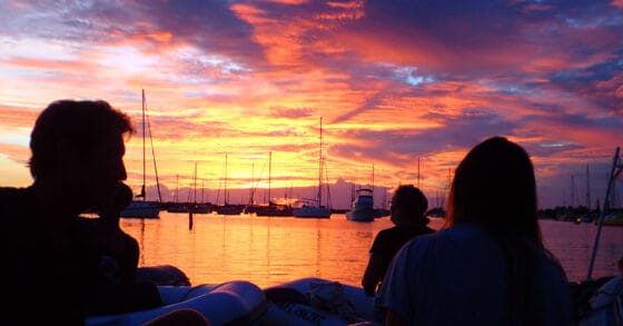 Silhouettes of people watching the sunset - sunset traditions