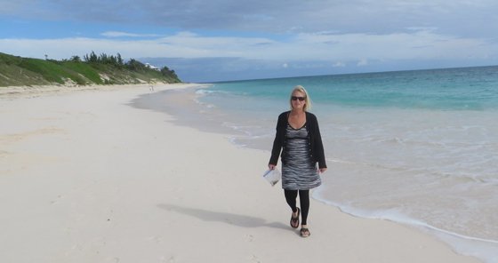 Michele walking along a Bahamian beach with her footless compression stocking on