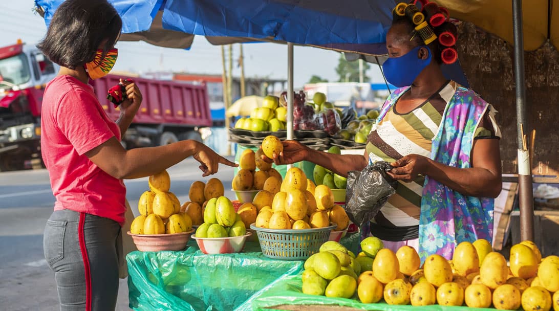 You can only buy what th store has - photo of woman buying produce at outdoor market under a tent