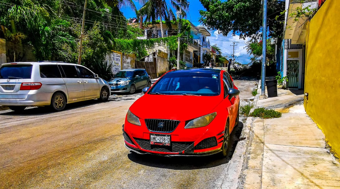 Red car parked at the curb - getting around on land when you live on a boat