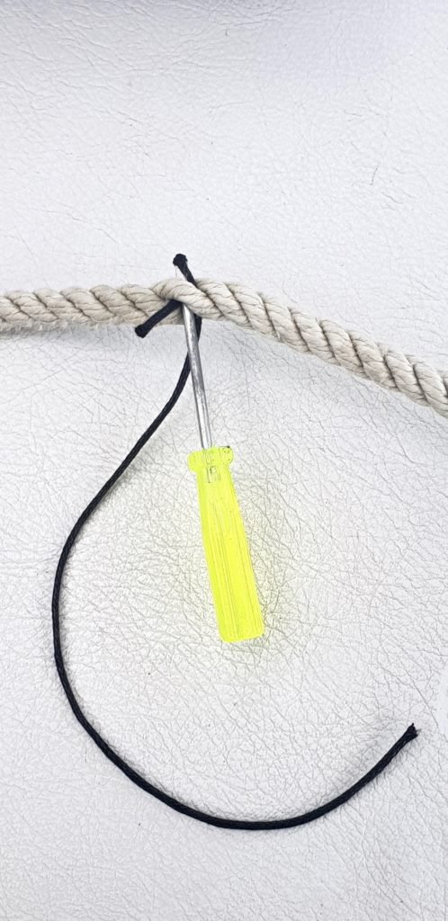 Use a screwdriver to force waxed cord through three-strand cord to make a boat clothesline.