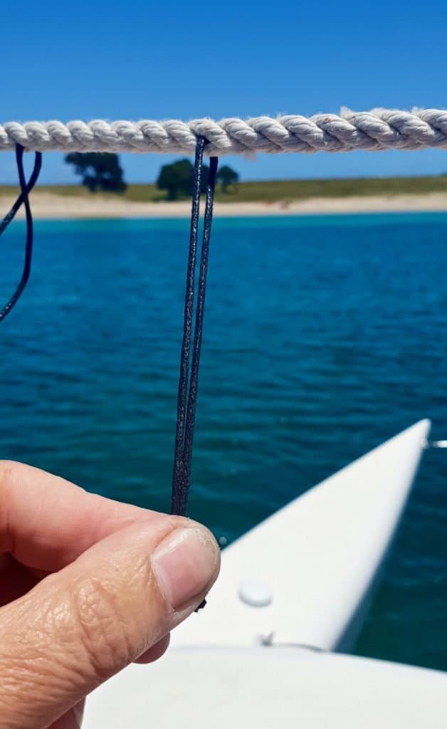 Hold a loop of waxed cord put through a single strand of three-strand line.