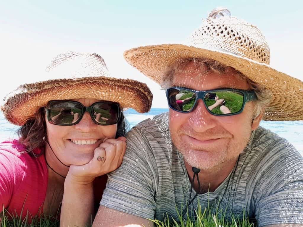 Woman and man in sunglasses and straw hats.