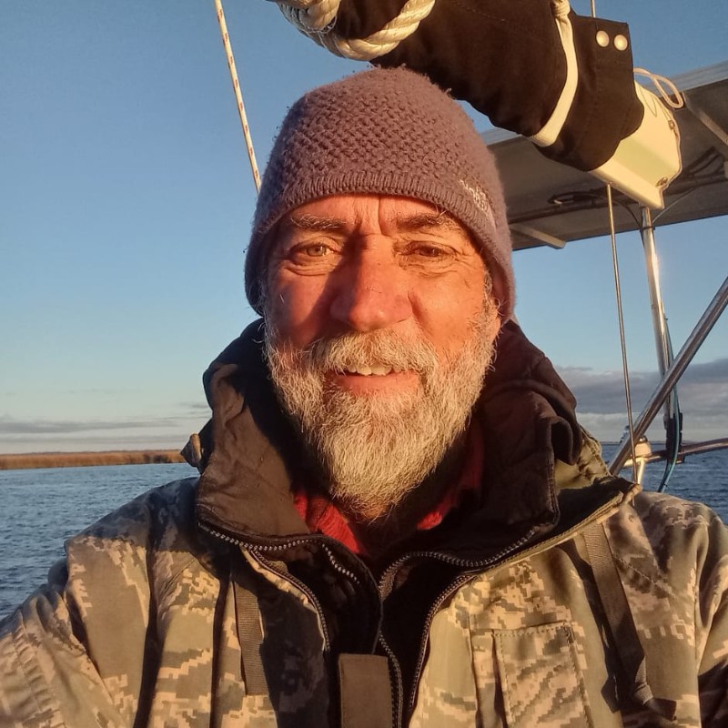 Male sailor on sailboat on a chilly day