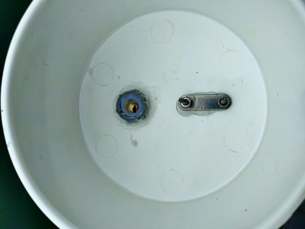 Bottom of bucket with u-bolt and drain set in for boat garden