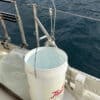 bucket on a boat deck catching rainwater