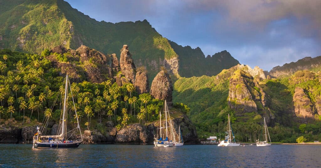 Boat anchored with mountains in the background - provisioning in the Marquesas
