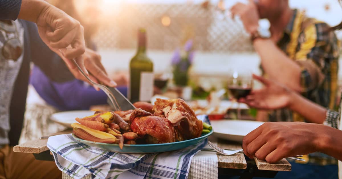 Man carving a turkey outdoors - celebrating thanksgiving when cruising