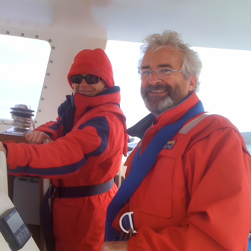 Couple at the helm of a boat in foul weather jackets