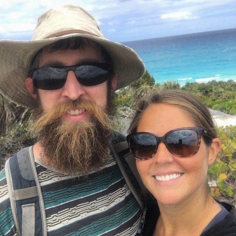 Young cruising couple ashore with ocean behind them
