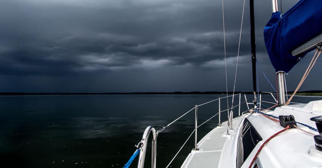 sailboat anchored under a dark sky