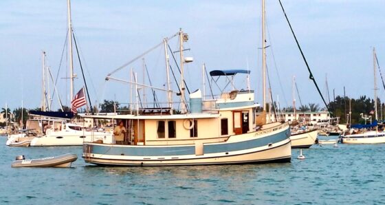 Trawler at anchor towing a dinghy - boat insurance: hull values and premiums