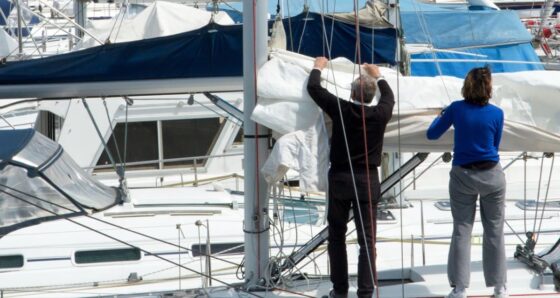 Couple inspecting sails on a boat - deal killers when buying a boat