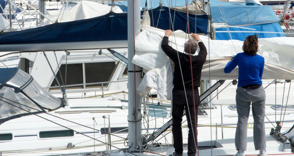 Couple inspecting sails on a boat - deal killers when buying a boat