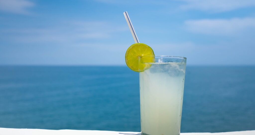 cold lime drink resting on a boat with the open sea behind it, a reminder to avoid dehydration on a boat