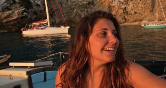 Elena smiling at sunset aboard Kittiwake, reflecting on telling her family she was going cruising