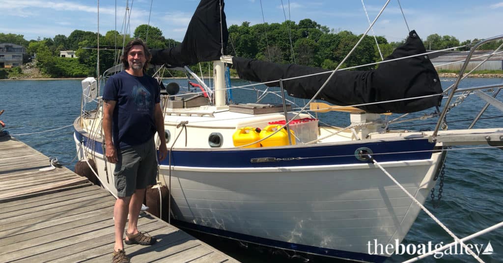 Larry Webber standing beside the boat he just agreed to purchase