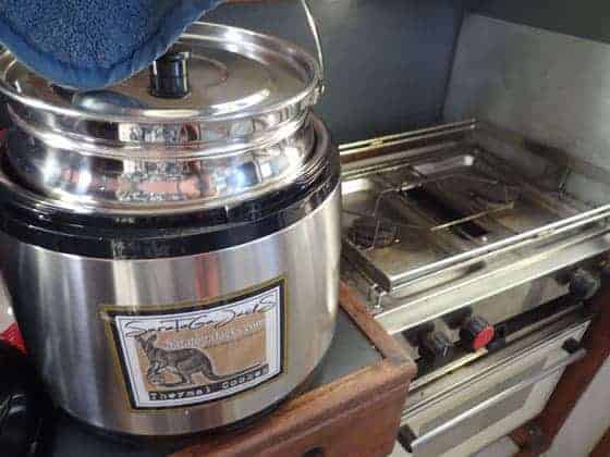 Putting food pans inside thermal container of the thermal cooker.