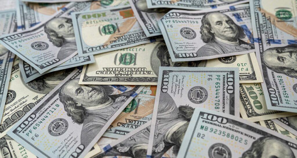 Pile of US $100 bills representing how much to offer on a used boat