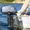 Person in life vest operating a small outboard motor on an aluminum boat